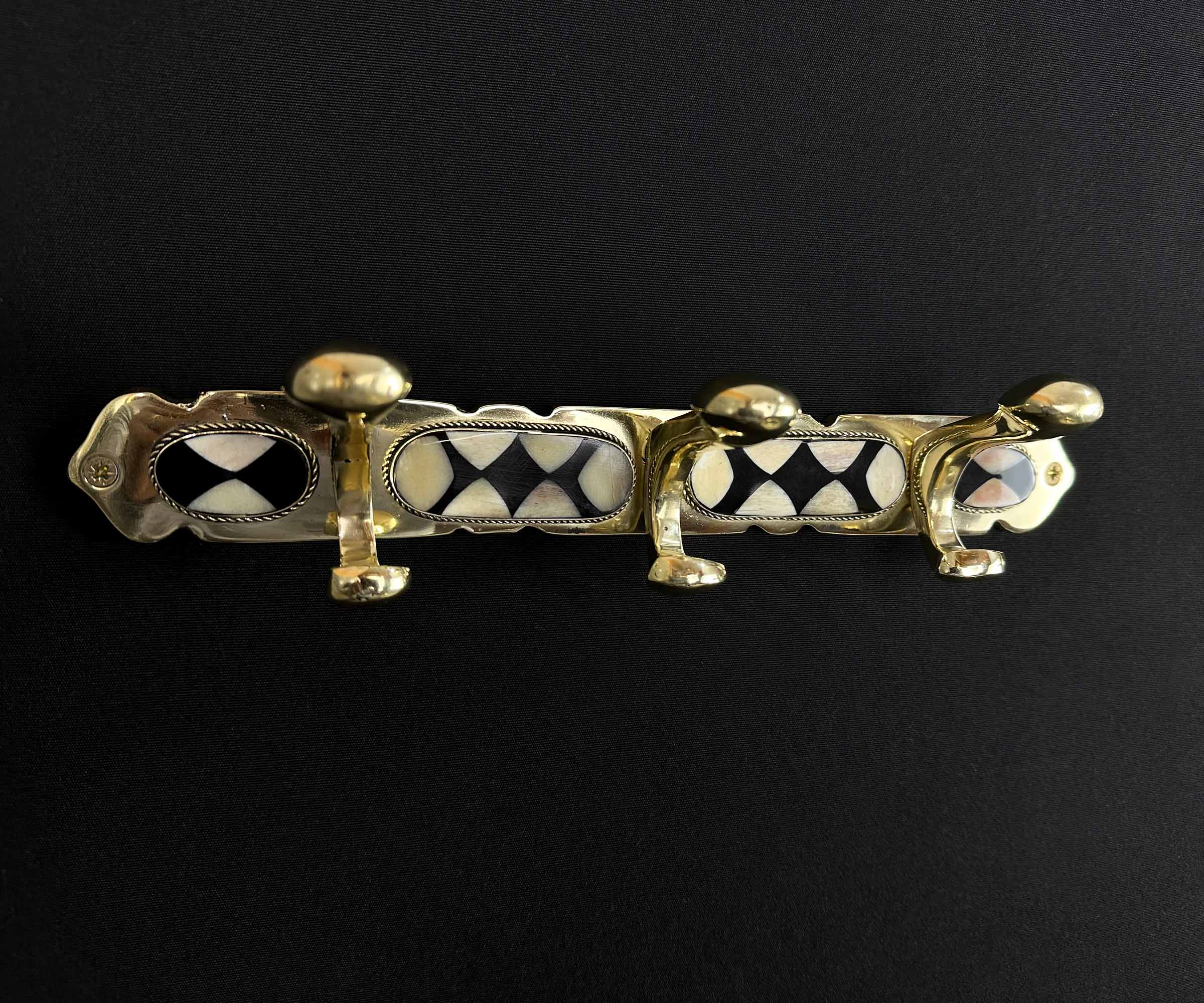 Handcrafted Moroccan wall hooks made of brass with bone and resin inlay.