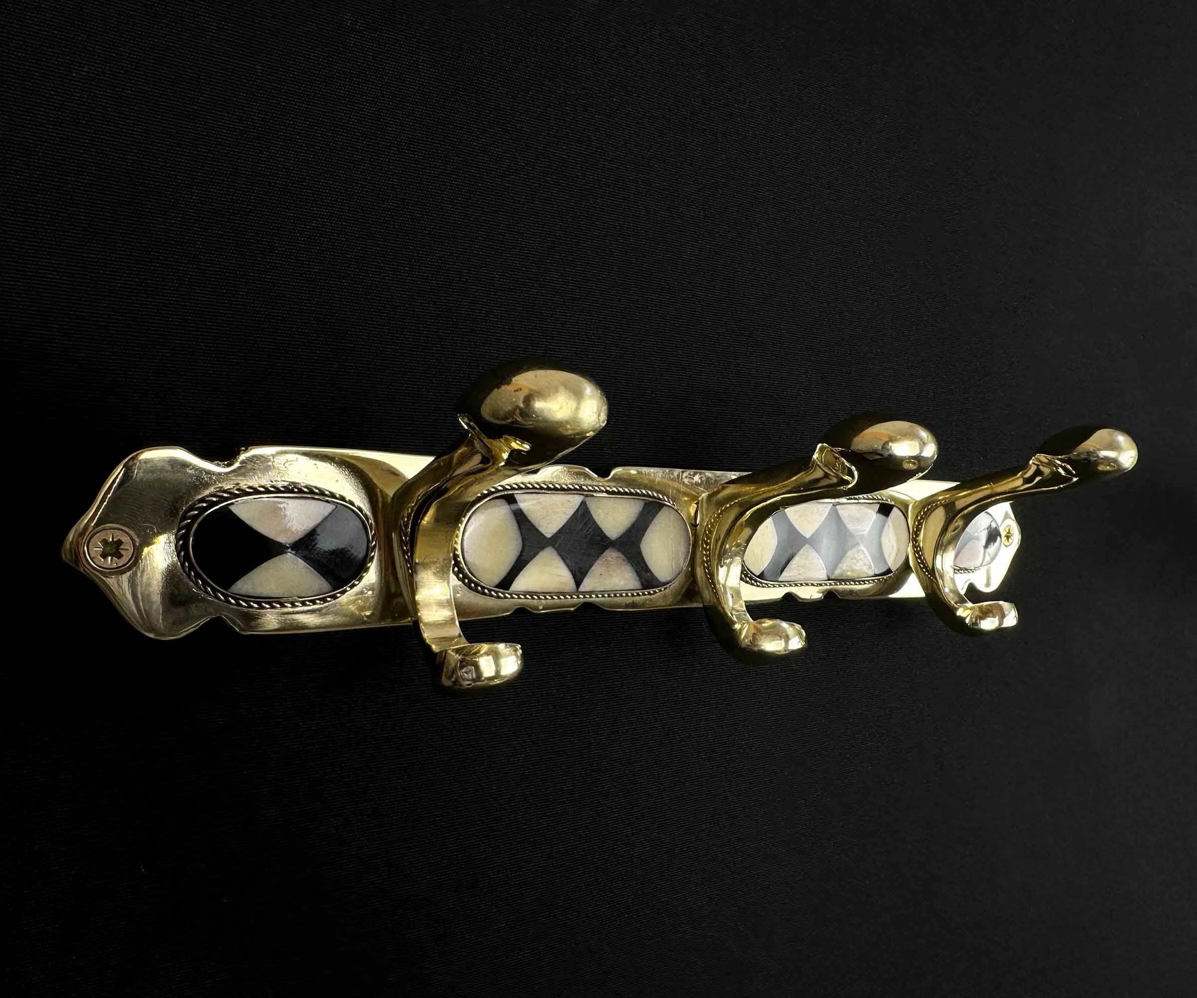 Moroccan-style brass wall hooks with intricate bone and resin design.